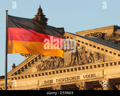 A German national flag flies in front of the Reichstag building in the light of the setting sun in Berlin, Germany on 30 June 2010. Inside, the presidential election takes place. Photo: Jens Wolf Stock Photo