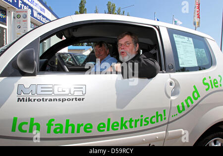 Federal state Mecklenburg-Vorpommern's Minister of Transport Volker Schlotmann rides an electric-powered 'Smart' in Rostock, Germany, 01 July 2010. The minister informed himself on the possibilities of deploying electr-powered vehicles in the tourism industry. Photo: Bernd Wuestneck Stock Photo