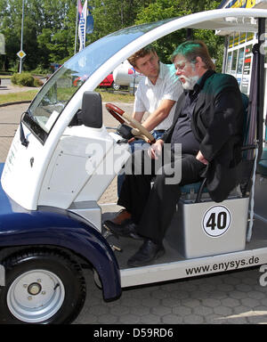 Federal state Mecklenburg-Vorpommern's Minister of Transport Volker Schlotmann rides an electric-powered 'Smart' in Rostock, Germany, 01 July 2010. The minister informed himself on the possibilities of deploying electr-powered vehicles in the tourism industry. Photo: Bernd Wuestneck Stock Photo