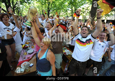 Fans of the German soccer team cheer after the World Cub quarterfinal-game Germany against Argentina in a public viewing area within a biergarden in Munich (Upper Bavaria). Germany wins 4:0. Photo: Andreas Gebert dpa/Iby Stock Photo