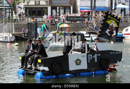 At the 23rd installment of the washtub race on the Alte Strom ('old stream'), imaginatively designed naval vehicles arrive at the Baltic Sea bath Warnemuende in Rostock, Germany, 03 July 2010. Ten teams participated in the traditional spectacle at the start of the Warnemuende Week. Photo: Bernd Wuestneck Stock Photo