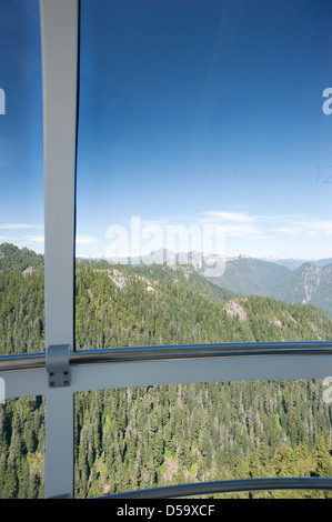 Looking out the window from the observation deck of the Eye of the Wind wind turbine towards the mountains of North Vancouver Stock Photo