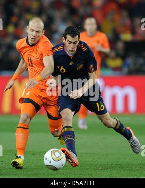 Dutch Arjen Robben (L) vies for the ball with Spain's Sergio Busquets during the 2010 FIFA World Cup final match between the Netherlands and Spain at Soccer City Stadium in Johannesburg, South Africa 11 July 2010. Photo: Marcus Brandt dpa - Please refer to http://dpaq.de/FIFA-WM2010-TC Stock Photo
