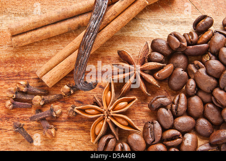 Coffee beans, star anise, vanilla pod, cloves and cinnamon bark on the wood desk Stock Photo