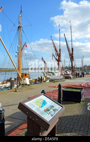 Information panel on Hythe Quay vessels at quayside & Thames Barge sails laid out in winter sunshine River Blackwater estuary beyond Maldon Essex UK Stock Photo