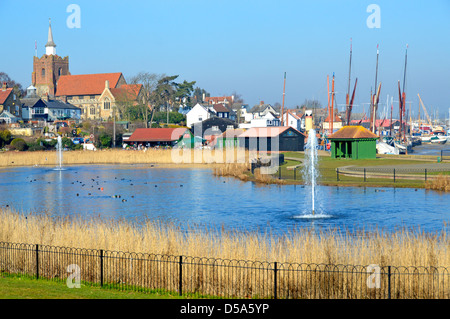 Pond & fountain landscape in Promenade Park adjoins River Blackwater estuary church & masts of Thames sailing barges beyond in Maldon Essex England UK Stock Photo