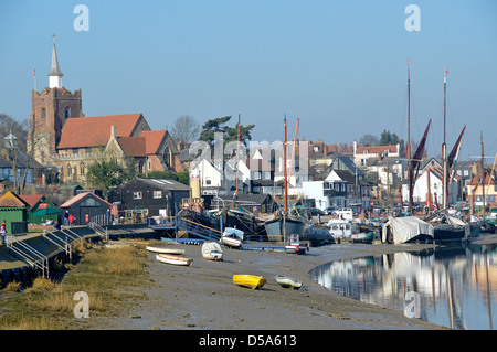 Hythe Quay boats at moorings with mud foreshore of the River Blackwater at low tide with St Marys church & tower beyond Maldon Essex England UK Stock Photo