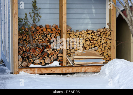 cut wood and logs in a wood store in the snow outside a house kirkenes finnmark norway europe Stock Photo