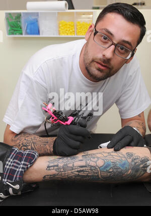 German rapper Sido poses with a tattoo needle as he opens his own tattoo studio 'ME And my kitty' in Berlin, Germany, 17 July 2010. Sido employs three tattoo artists and one piercer, he aims to learn the art of tattooing himself oneday. Photo: Britta Pedersen Stock Photo