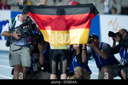 German javelin thrower Linda Stahl holds up a German flag at the Olympic stadium Lluis Companys during the European Athletics Championships in Barcelona, Spain, 29 July 2010. Photo: Rainer Jensen Stock Photo