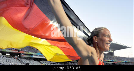 The German heptathlete Jennifer Oeser celebrates her bronze medal with a flag at the European Athletics Championships at Olympic Stadium Lluis Companys in Barcelona, Spain, 31 July 2010. The World Cup second from Leverkusen crowned her excellent heptathlon performance with a personal best. Photo: Rainer Jensen Stock Photo
