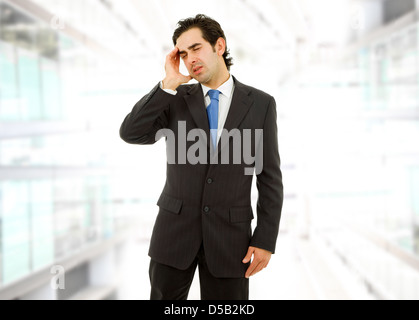 Businessman in a suit gestures with a headache Stock Photo