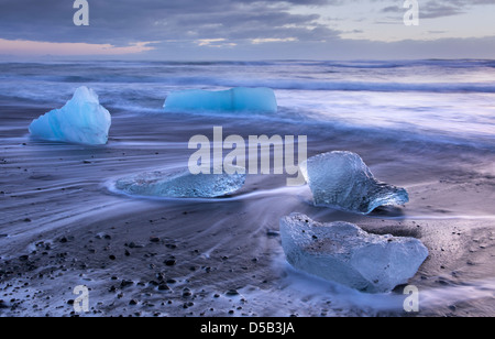 Ice blocks washed ashore on a sand beach. Near Jökulsarlon glacier bay, Southern Iceland. Stock Photo