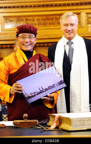 Spiritual head of Tibetan Drukpa-order, his holyness the 12. Gyalwang Drukpa (L), is greeted by Hamburgs first mayor Ole von Beust (CDU) (R) in Hamburg, Germany, 05 January 2010. In his hand the guest holds a pictorial, which he recieved earlier. Afterwards, the student of the Dalai Lama wanted to sign the city's golden book. The Drupka-order is one of the Tibetan buddhist schools  Stock Photo