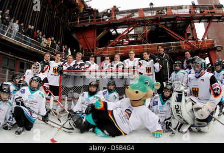 The mascot of the Ice Hockey World Cup 2010 'Urmel auf dem Eis' ('Urmel on the Ice') poses in front of members of the junior team of 'Moskitos Essen' and members of the German national ice hockey squad during a photo call on the ice rink at the former coal pit 'Zeche Zollverein' in Essen, Germany, 06 January 2010. The Ice Hockey World Cup 2010 takes place in Germany from 07 May to  Stock Photo