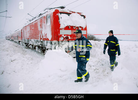 Members of Germany's Technical Relief Organisation ('Technisches Hilfswerks' (THW)) help during the rescue action for a train stuck in the snow on the track between Stralsund and Berlin near Anklam, Germany, 11 January 2010. The rescue work of the train which got stuck in snow on 10 January shall be initiated in the course of the day and last until late afternoon. Snow drifts conti Stock Photo
