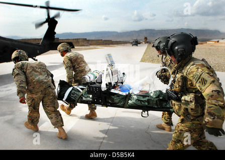 US Soldiers carry a wounded Afghan army soldier to a waiting UH-60 Black Hawk helicopter during a medical evacuation mission February 20, 2013 at Tarin Kowt, Uruzgan province, Afghanistan. Stock Photo