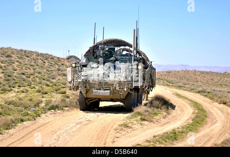 USA Stryker armored vehicle provides security as Afghan Border Police break ground on a new checkpoint March 25, 2013 in the district of Spin Boldak, Kandahar province, Afghanistan. Stock Photo