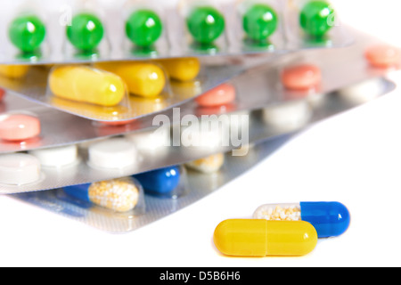 Pills (capsules) close up and stack of blisters isolated on white background. Selective focus. Stock Photo