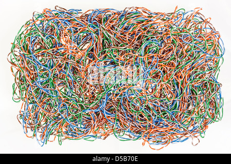 The confused mixed computer wires lies on white table abstract background. It's don't isolated image. Stock Photo