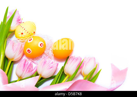 Easter border made of painted Easter eggs, pink tulips and silk ribbon isolated on white background Stock Photo