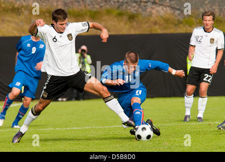 German player Dennis Dieckmeier (L) can proceed against Iceland's Johann Berg Gudmundsson (C), while Philipp Bargfrede (R) observes the duel during the U 21 match Germany vs. Iceland of the European Championship qualification in Hafnarfjoerdur, Iceland, 11 August 2010. Photo: Halldor Kolbeins Stock Photo