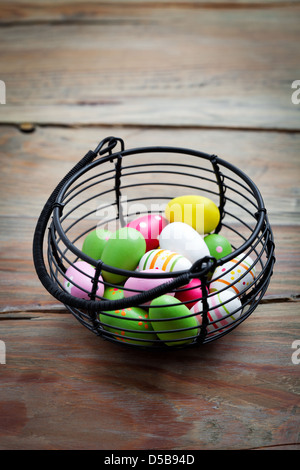 Colorful easter eggs in black wire basket Stock Photo