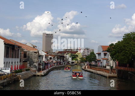 A view of Malacca / Melaka river in Malaysia. Passengers on cruise river boats. Stock Photo