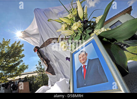 Curtained with a white cloth, the memorial for civil courage stands in front of the Dominik-Brunner-House before its unveiling in Ergoldsbach (district Landshut, Lower Bavaria), Germany, 12 September 2010. On 12th September 2009, manager Dominik Brunner was beaten down by juveniles at Munich's S-bahn station Solln and died consequently of a sudden heart failure. Photo: Peter Kneffe Stock Photo