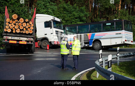 Two police officers examine the scene after a Polish lorry that carried tree trunks crashed with a coach on the Autobahn A13 near Freiwalde, Germany, 15 September 2010. According to information released by the police, 17 people were injured, four of them seriously. Photo: Patrick Pleul Stock Photo