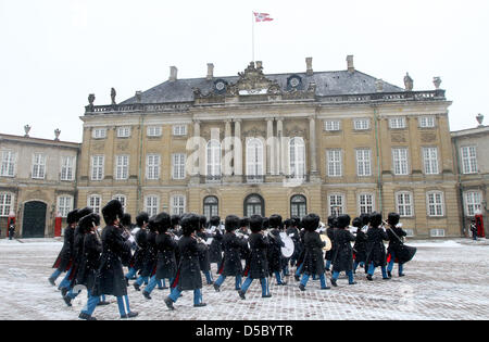 Guards parade in front of Christian IX Palace of Amalienborg Palace in Copenhagen, Denmark, 20 January 2010. It consists of four identical palaces with a square in the cente featuring a monumental equestrian statue of Amalienborg's founder, King Frederick V. Christian IX Palace is the residence of Queen Margrethe of Denmarl and Henrik Prince Consort of Denmark. Photo: Patrick van K Stock Photo