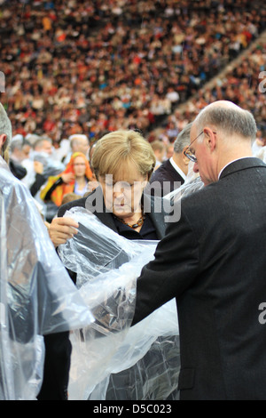 Angela Merkel Norbert Lammert celebrating the Mass of Pope Benedict XVI at olympic stadium wearing rain coats. Berlin, Germany Stock Photo