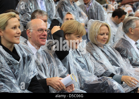 Norbert Lammert Bettina Wulff Angela Merkel celebrating the Mass of Pope Benedict XVI at olympic stadium wearing rain coats. Stock Photo