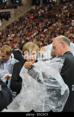 Angela Merkel Norbert Lammert celebrating the Mass of Pope Benedict XVI at olympic stadium wearing rain coats. Berlin, Germany Stock Photo