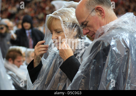 Angela Merkel Norbert Lammert celebrating the Mass of Pope Benedict XVI at olympic stadium wearing rain coats. Berlin, Germany Stock Photo