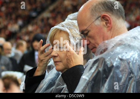 Angela Merkel Norbert Lammert celebrating the Mass of Pope Benedict XVI at olympic stadium wearing rain coats. Berlin, Germany Stock Photo