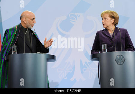 German Chancellor Angela Merkel and Afghan President Hamid Karzai give a press conference on the upcoming Afghanistan conference in London in the Chancellery in Berlin, Germany, 27 January 2010. The German government plans to prepare the retreat of German soldiers from Afghanistan with a new strategy until 2014, while the number of soldiers is increased by 850 to 5350 and developme Stock Photo