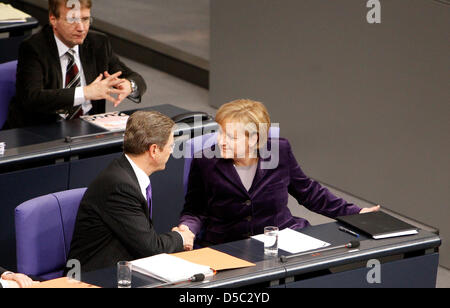 German Chancellor Angela Merkel (R) and Foreign Minister Guido Westerwelle chat after Merkel's government statement on the German engagement in Afghanistan in front of the Bundestag in Berlin, Germany, 27 January 2010. Ronald Pofalla, Minister of the Chancellery is pictured in the background. In the name of her government and the deployed soldiers Merkel thanked the parliament for  Stock Photo