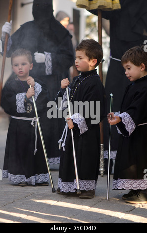 Three children during a procession in Holy week, semana santa in Mijas Pueblo, Malaga province, Spain. Stock Photo