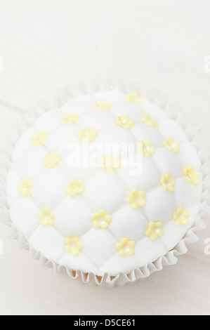 Cupcake with fondant icing and sugarcraft blossom decorations Stock Photo