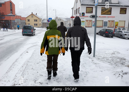 couple walking down kirkegata main street covered in snow during winter hammerfest finnmark norway europe Stock Photo