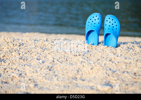 Blue sandals on the beach with shallow depth of field Stock Photo