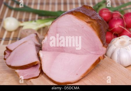 ham cut in slices on board and vegetables Stock Photo