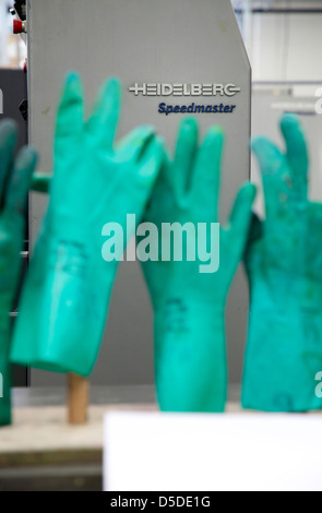 Geldern, Germany, green rubber gloves at the printers before a Heidelberg printing press Stock Photo