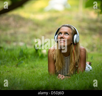 Happiness girl with headphones enjoying nature and music at sunny day Stock Photo