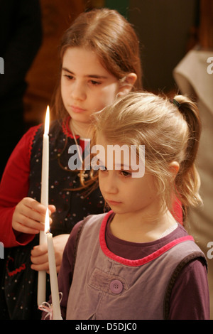 Small girls hold a candle in the Orthodox church Stock Photo