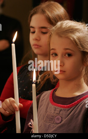 Small girls hold a candle in the Orthodox church Stock Photo