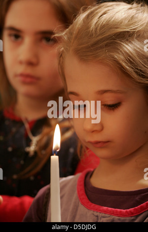 Small girls hold a candle in the Orthodox church Stock Photo