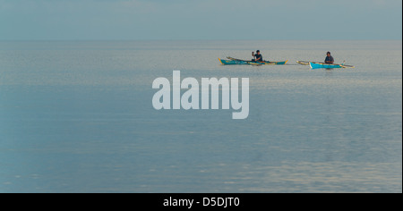 Two men greeting each other while they pass each other in their boats Stock Photo