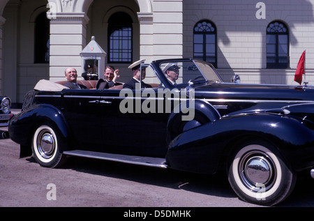 On his birthday in 1963, the King of Norway, Olav V, and his only son, Crown Prince Harald, ride in the open royal limousine through Oslo, Norway. Stock Photo